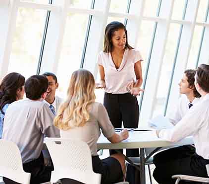 Woman Leading Business Meeting in White Room with Windows